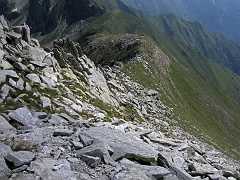 Lo sguardo cerca Giancarlo tra i massi poi raggiunge la dorsale che sale dal Passo di Basagrana...